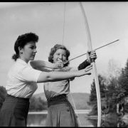 Une monitrice enseigne le tir à l’arc à une campeuse de la colonie de vacances «Wooden Acres», 1942, Conrad Poirier, BAnQ, P48,S1,P7443